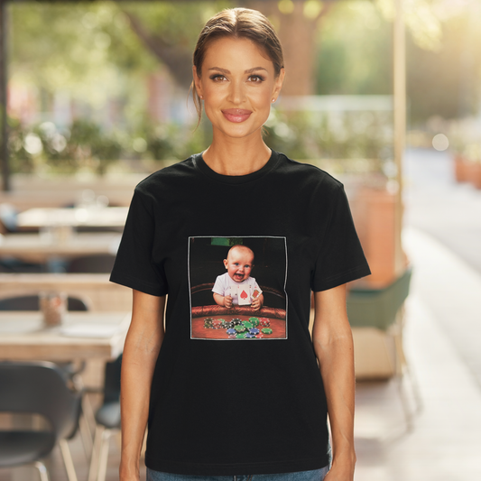 Female model wearing Crazy Tiny Card Shark Baby graphic T-shirt at an outdoor cafe